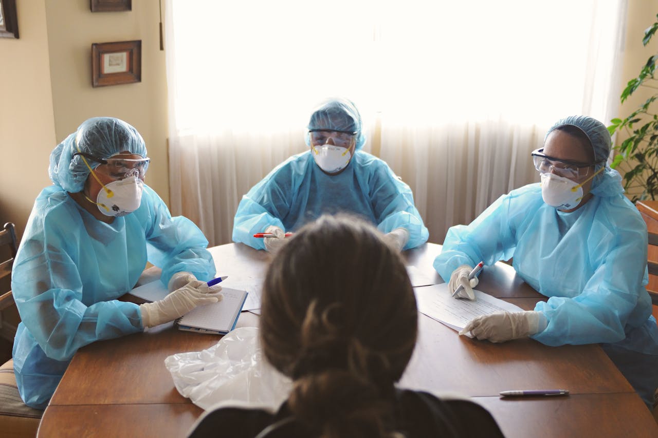 healthcare-workers-in-ppe-conducting-a-meeting-33642017